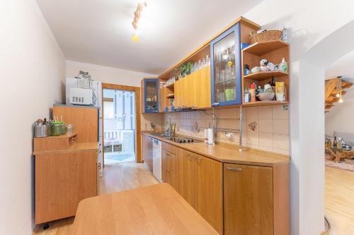 a kitchen with wooden cabinets and a wooden table at Domeček na samotě in Terezín