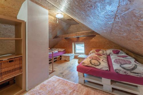 a bedroom with two beds in a attic at Domeček na samotě in Terezín
