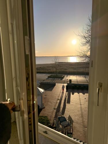 a room with a window with a view of a beach at Strandhotel Strande in Strande