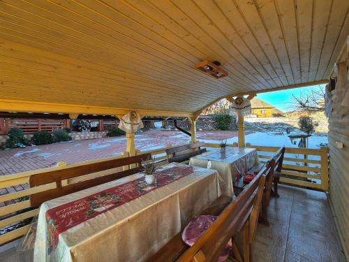an outdoor dining area with benches and a wooden ceiling at Pensiunea Inima Maramureșului in Breb