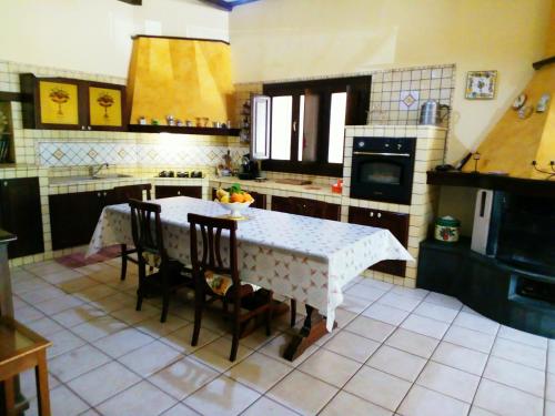 a kitchen with a table and some chairs and a table and a kitchen at Villa Gabry in Floridia