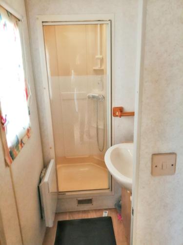 La petite salle de bains est pourvue d'une douche et d'un lavabo. dans l'établissement Bungalow charmant à Saint-Pierre-d'Oléron avec jardin clôturé, à Saint-Pierre-dʼOléron