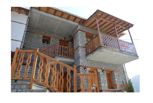 a house with a balcony and a wooden staircase at La Petri Studios with Fireplace & View in Metsovo