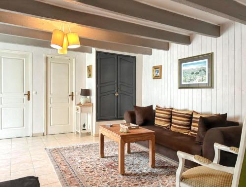 a living room with a couch and a table at Maison de charme à Sigogne, proche de Cognac, barbecue inclus. in Sigogne