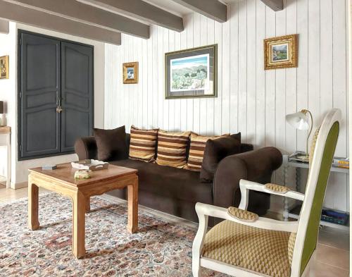a living room with a couch and a table at Maison de charme à Sigogne, proche de Cognac, barbecue inclus. in Sigogne