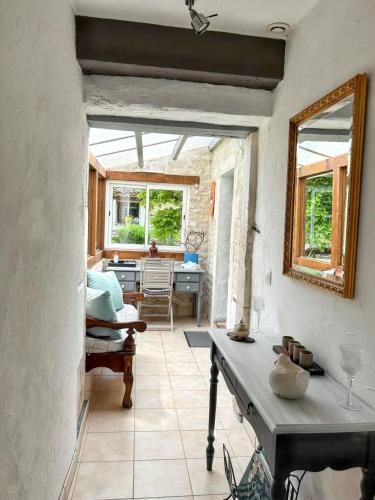 a living room with a table and a window at Maison de charme à Sigogne, proche de Cognac, barbecue inclus. in Sigogne