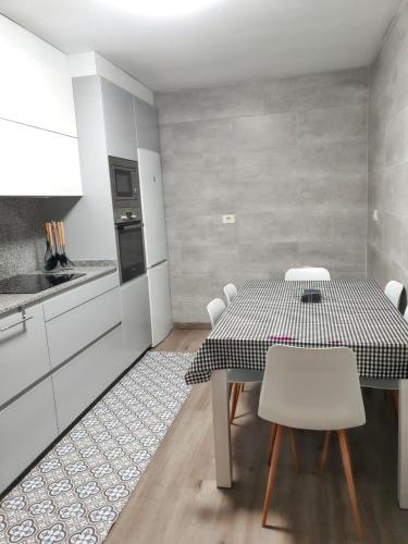 a kitchen with a table and chairs in a room at Spacious apartment with sea view in O Grove, 110 m² in O Grove