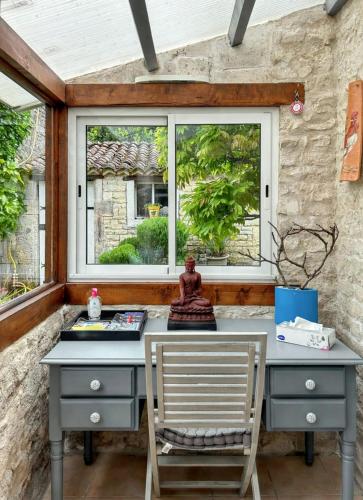 a desk and a chair in front of a window at Maison de charme à Sigogne, proche de Cognac, barbecue inclus. in Sigogne