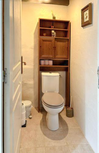 a bathroom with a toilet and wooden cabinets at Maison de charme à Sigogne, proche de Cognac, barbecue inclus. in Sigogne