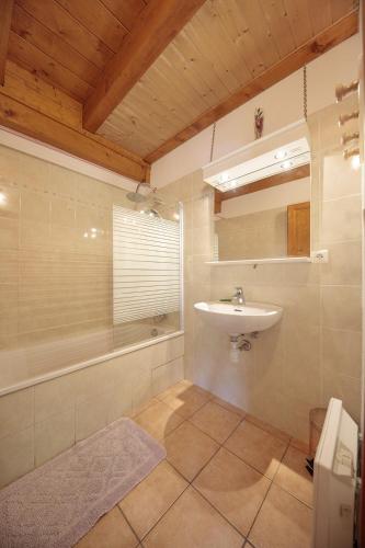 une salle de bain avec un lavabo et une baignoire et un lavabo dans l'établissement Le Myosotis, à Morillon