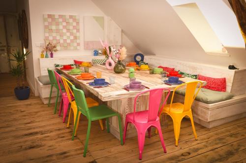 a kitchen with a long table with colorful chairs at Magnifique Loft Festif in Saint-Pourçain-sur-Sioule