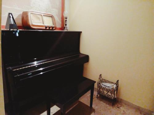a black piano with a radio on top of it at Villa Gabry in Floridia