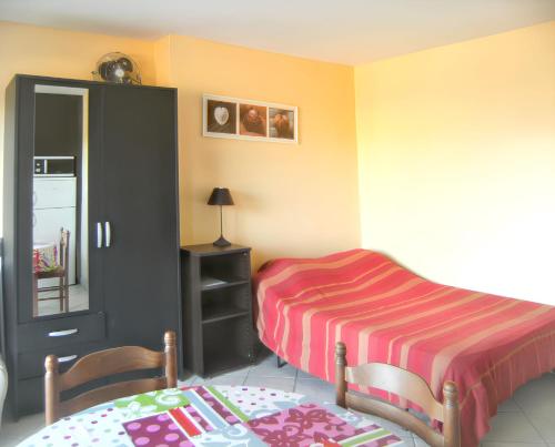 une chambre avec un lit, une table et des chaises dans l'établissement Studio charmant à Hyères - 20 m² - Terrasse accueillante, à Hyères