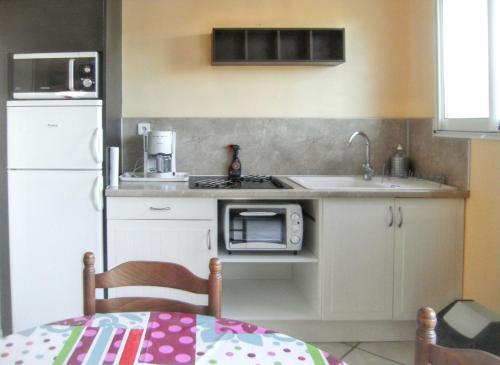 une petite cuisine avec un évier et un micro-ondes dans l'établissement Studio charmant à Hyères - 20 m² - Terrasse accueillante, à Hyères