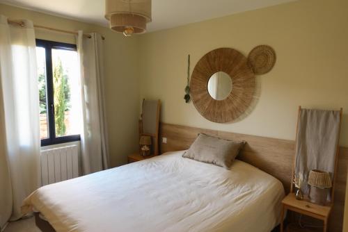 une chambre avec un lit et un miroir au mur dans l'établissement L'Abri de Malaucène - Gîte Cycliste, à Malaucène