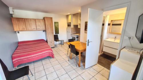 a small room with a bed and a table at Studio charmant à Hyères, 20 m², jardin et parking privé in Hyères