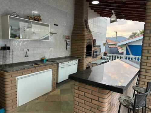 アチバイアにあるRecanto Aparecida lazer, piscina climatizadaの白いキャビネットとレンガの壁が備わるキッチン