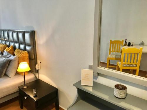 a bedroom with a bed with a mirror and a chair at Eleana Apartments in Hersonissos