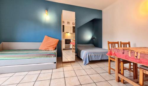 a room with two beds and a table in it at Studio confortable à Hyères avec terrasse et jardin – 20 m² in Hyères