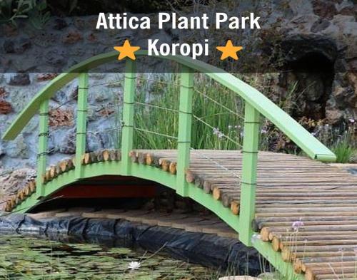 a green bridge over a pond in a park at ATHENS VILLA KROPIA #AthensAirport #AirView #Sunrise in Koropíon