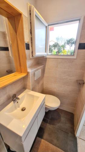 une salle de bain avec un lavabo et des toilettes et une fenêtre dans l'établissement Studio confortable à Hyères avec terrasse et jardin – 20 m², à Hyères