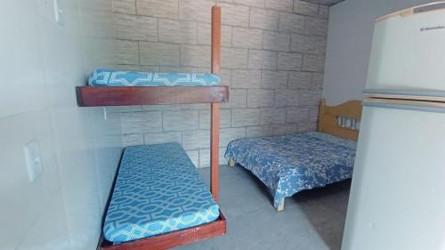 a room with two bunk beds and a refrigerator at Espaço da Família hospedagem Mairiporã in Mairiporã