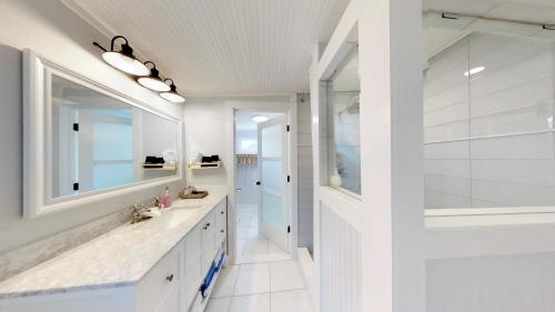 a white bathroom with a sink and a mirror at Renovated Lemon Guesthouse 4 KING Bedrooms Downtown Half Mile Stroll- Beach Only 3 Miles in Saint Augustine