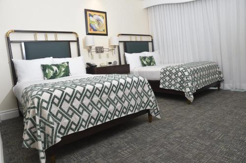 a hotel room with two beds at Courtleigh Hotel & Suites in Kingston