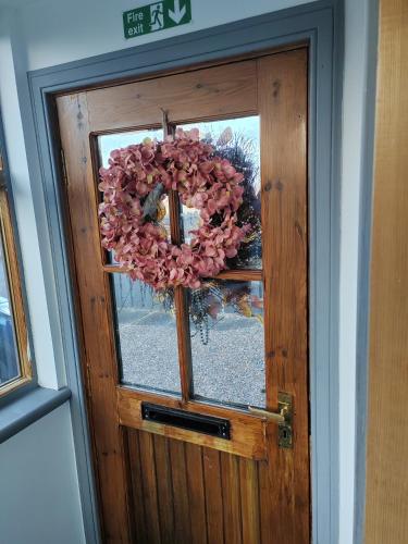 a door with a wreath on it with a window at Westview in Buckie