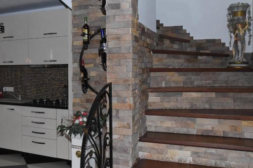 a staircase in a kitchen with a brick wall at Pensiunea Inima Maramureșului in Breb