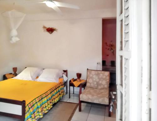 a bedroom with a bed and a chair at Studio accueillant à Sainte-Luce, 30 m² avec jardin privé in Sainte-Luce