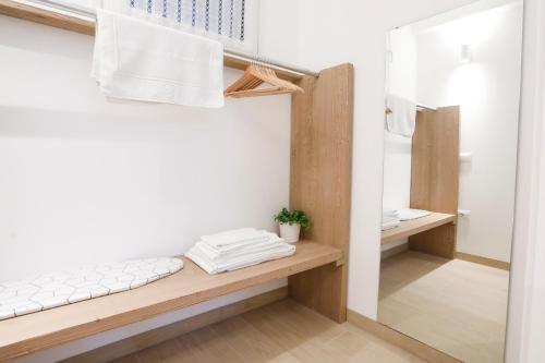 a bathroom with a bench and a mirror at Suite Alpina, profumo di legno e relax totale in Maso