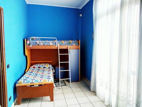 a bedroom with two bunk beds and a blue wall at Villa Gabry in Floridia