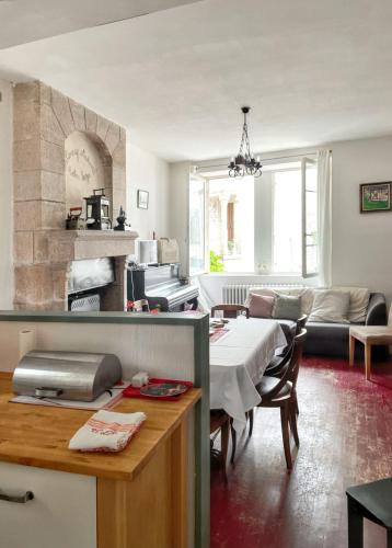 Il comprend une cuisine et un salon avec une table. dans l'établissement Maison charmante en Corrèze avec jardin et cheminée, à Corrèze