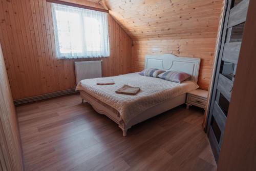 a bedroom with a bed in a wooden room at Гостьовий дім "У Ані" in Yablunytsya