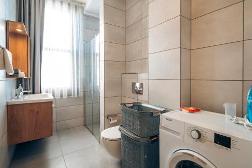 Un baño con lavadora y un inodoro. en Galata Guest Teori, en Estambul