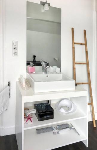 une salle de bain blanche avec un lavabo et un miroir dans l'établissement Maison charmante en Corrèze avec jardin et cheminée, à Corrèze