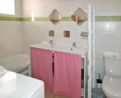 ein Badezimmer mit einem Waschbecken und einem rosa Duschvorhang in der Unterkunft Maison de caractère à Pierrefiche avec piscine privée in Pierrefiche