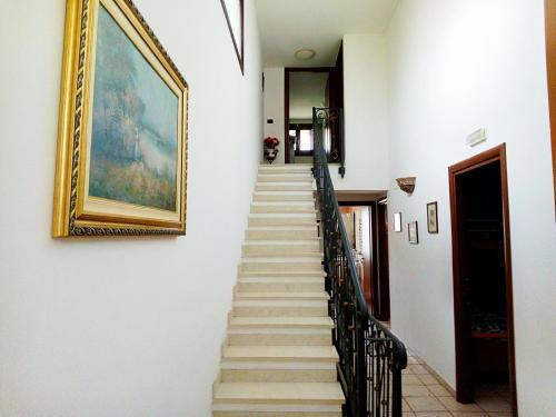 a stairway with a painting and a picture on the wall at Villa Gabry in Floridia
