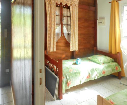 a bedroom with a bed and a window at Bungalow confortable à Deshaies avec vue mer, jardin clôturé in Deshaies