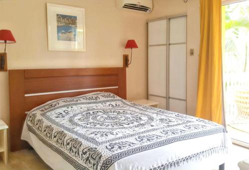 una camera con un letto con una coperta blu e bianca di Appartement familial avec piscine à Saint Gilles, 80 m² a Saint-Gilles-les Bains