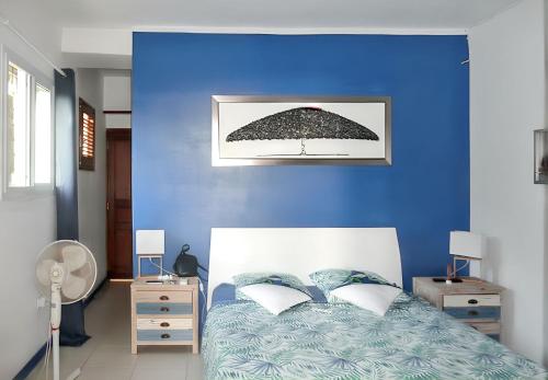 une chambre bleue avec un lit avec un parapluie dans l'établissement Maison spacieuse à Pointe-Noire avec piscine partagée 110 m², à Pointe-Noire