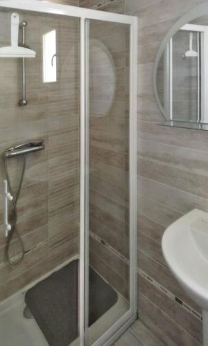 une douche avec une porte vitrée à côté d'un lavabo dans l'établissement Maison confortable avec vue montagne à Nant, piscine partagée, à Nant