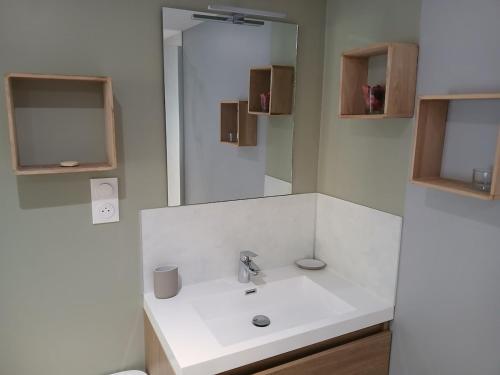 a white bathroom with a sink and a mirror at Les Terrasses Perchées sur l'Oudon Segré in Saint-Vincent