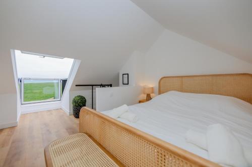Un dormitorio con una cama grande y una ventana. en La Vigie, maison face à la Canche, en Étaples