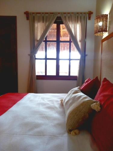a bedroom with a white bed with a window at Hotel Aldea Katún in Izamal
