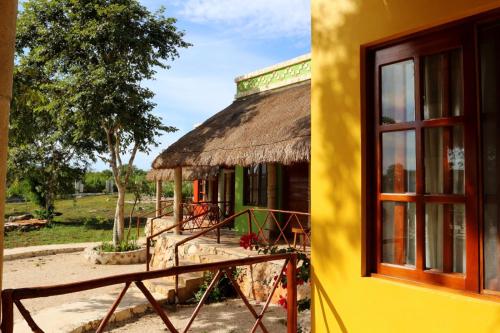 a building with a thatched roof and a window at Hotel Aldea Katún in Izamal