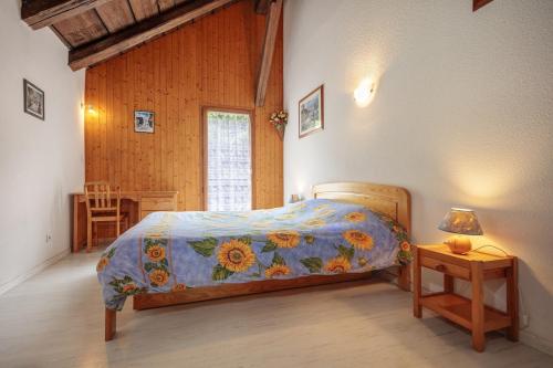 une chambre avec un lit et une table avec une lampe dans l'établissement Pervenche, à Morillon