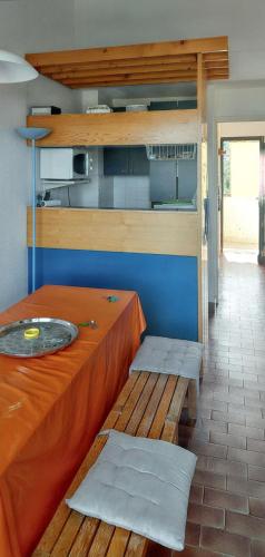 Cette chambre dispose d'une table, d'un banc et d'une cuisine. dans l'établissement Appartement cosy à Grosseto-Prugna - Vue sur la mer, 42 m², à Grosseto-Prugna