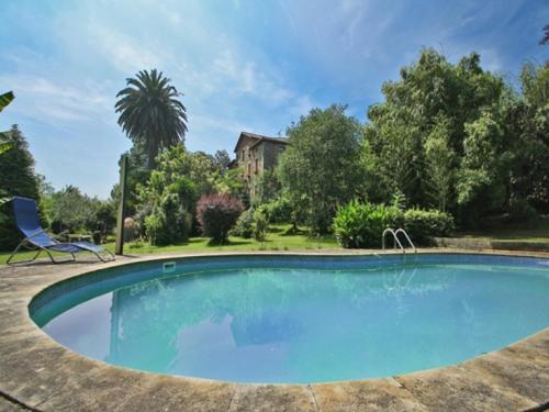 a swimming pool in a yard with a house at B&B El Jardín de Aes in Puente Viesgo